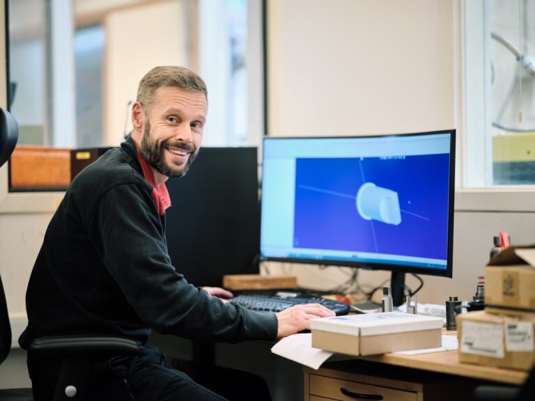 A male Lesjofors dedicated account manager sitting at his desk with a monitor.
