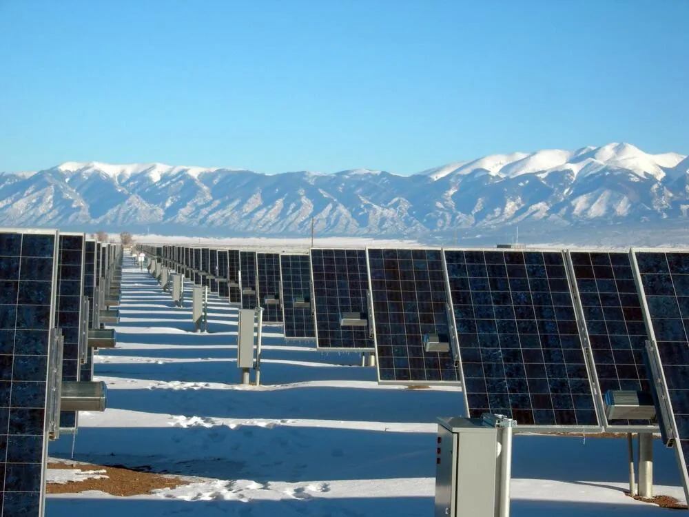 Rows of solar panels at a solar farm at a snowy, mountainous location, illustrating the role of Lesjöfors’ products in solar power generation. 