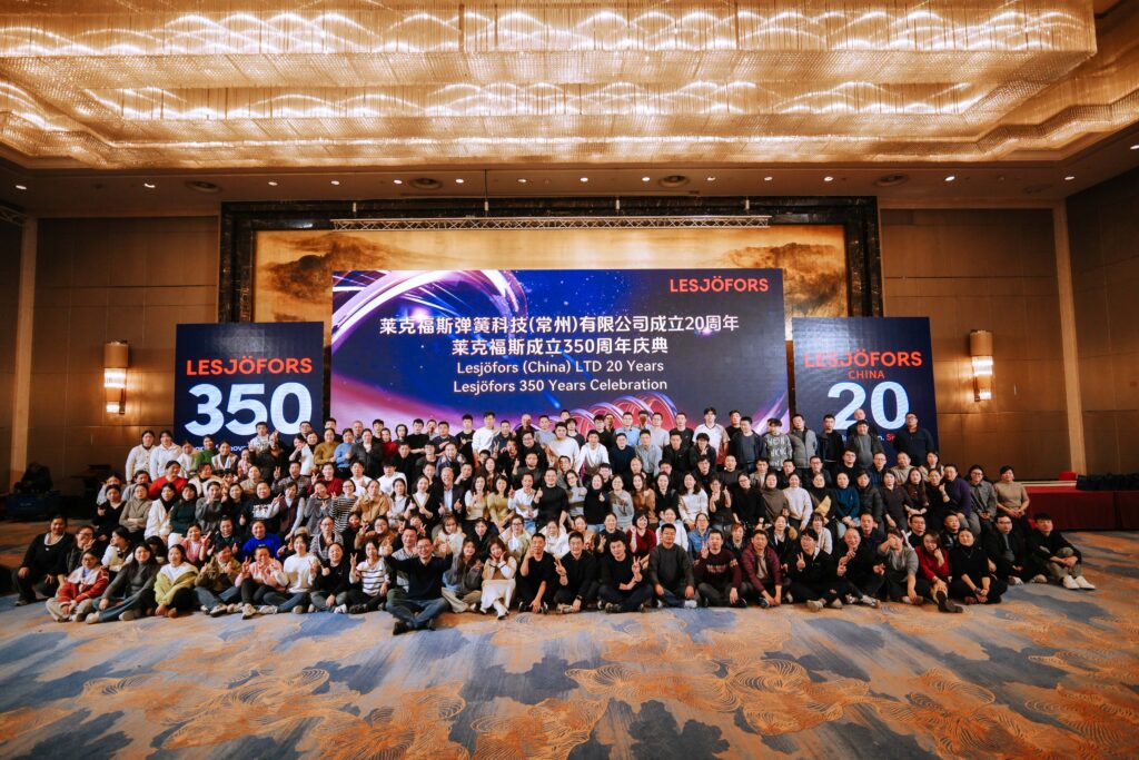 Large group of employees posing in front of a stage backdrop celebrating Lesjöfors China’s 20th anniversary and Lesjöfors’ 350-year milestone