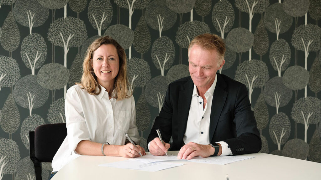 A woman and a man signing a contract.