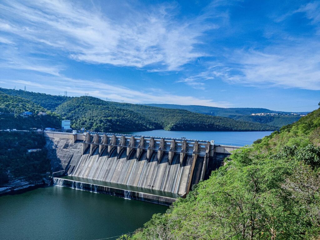 A landscape image showing a river with a dam, illustrating the role of Lesjöfors’ springs within hydroelectric power generation.