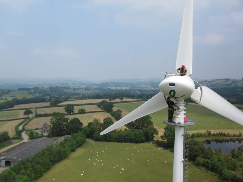 An engineer works on a wind turbine in a rural setting, illustrating the role of Lesjöfors’ springs in Earthmill’s wind turbine maintenance solutions.
